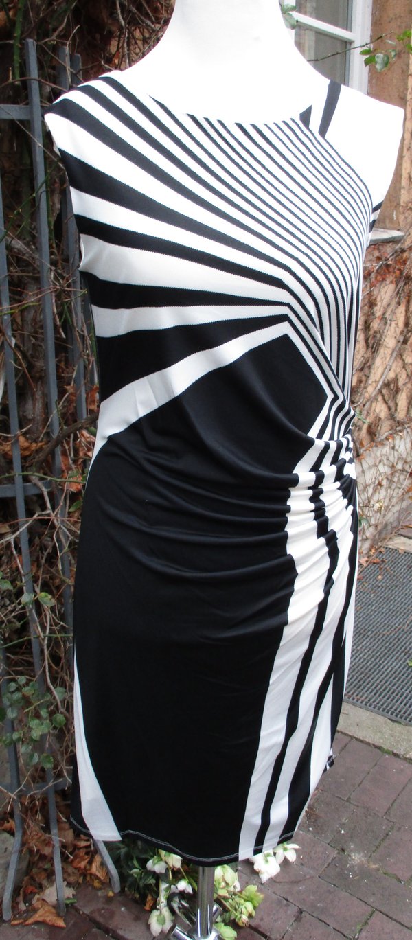 Kleid in Schwarz-Weiß, mit graphischem Muster. Seitlich kaschierend gerafft. Marke Tia