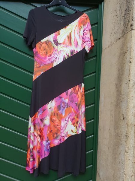 Kleid in Jersey. Schwarz, Diagonalstreifen mit fröhlichem floralem Muster. Marke Tia